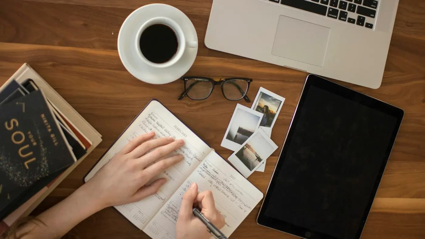 Planning notes, tablet and coffee on a desk seen from above