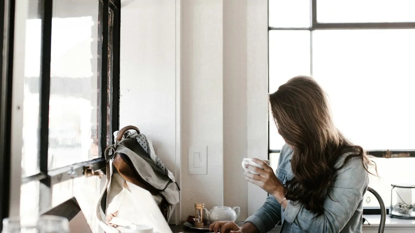 Woman working on a laptop in a bright cafe
