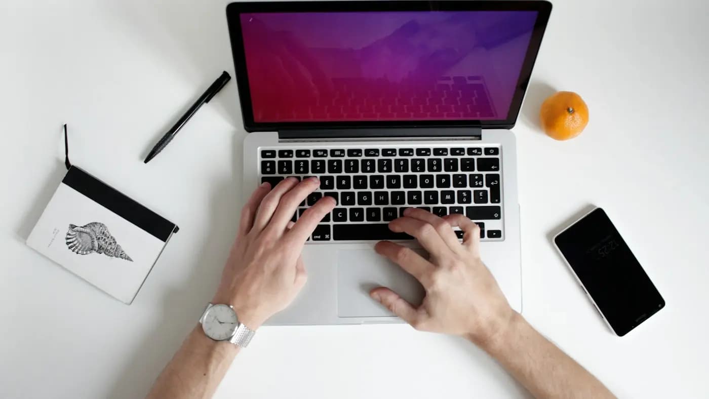 Hands typing on a laptop seen from above