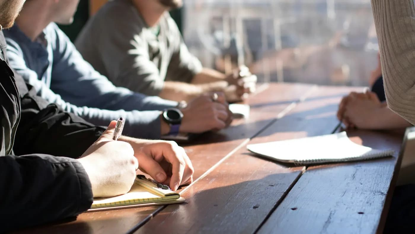 Colleagues in a meeting around a wooden table