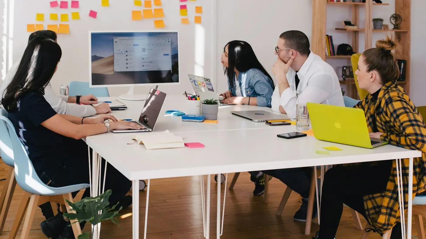 Team collaborating at a long white table with sticky notes