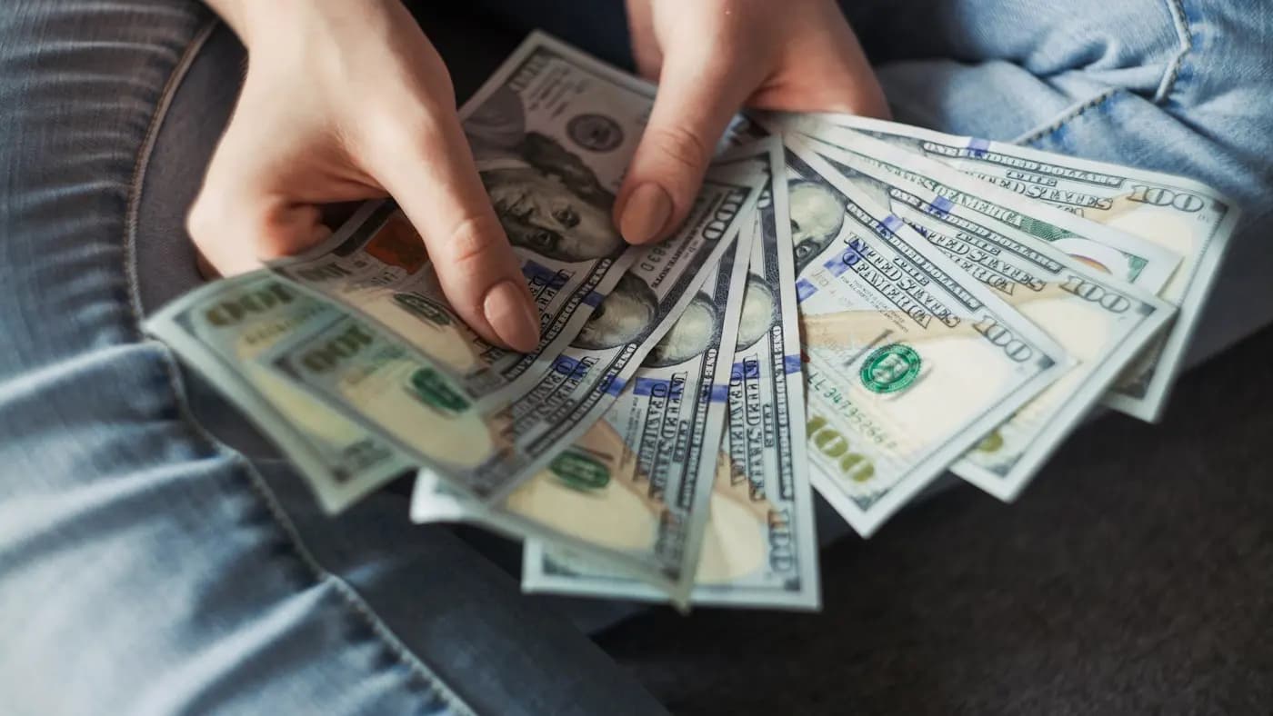 Hands holding a stack of banknotes