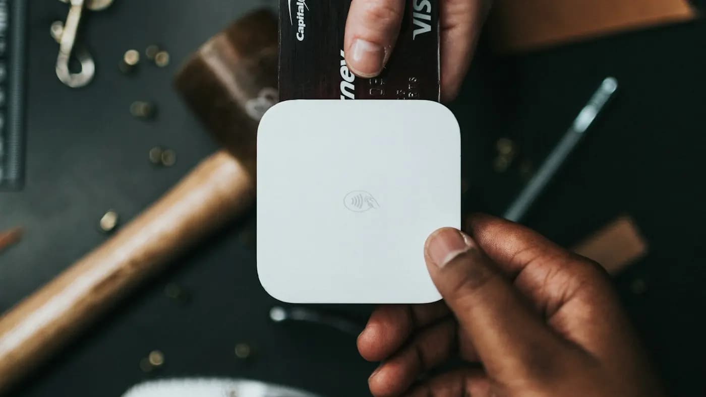 Hand holding a card reader on a dark workbench