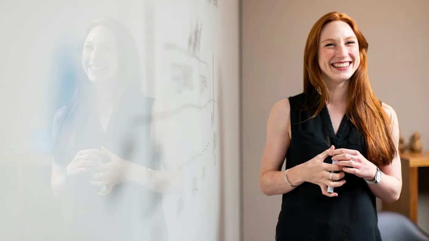Woman presenting in front of a whiteboard