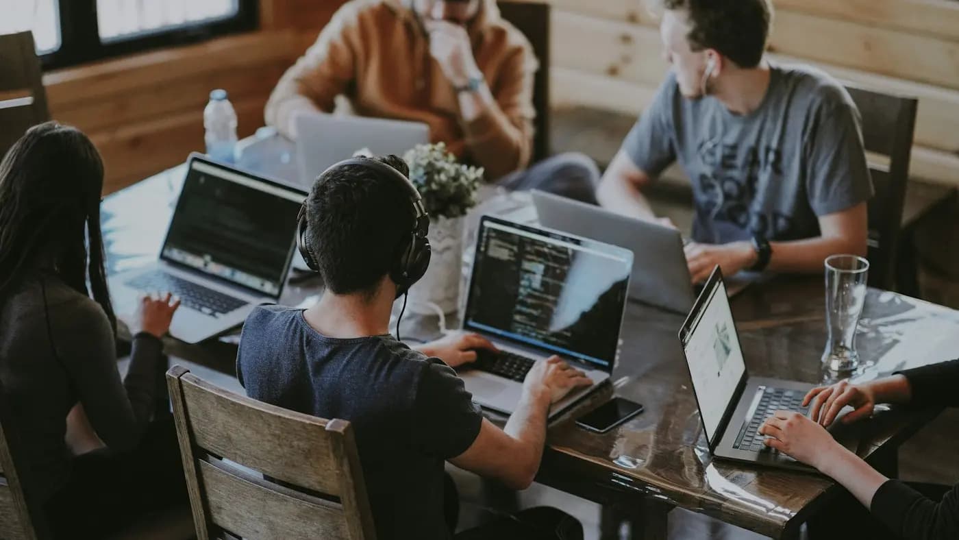 Colleagues working on laptops at a shared table