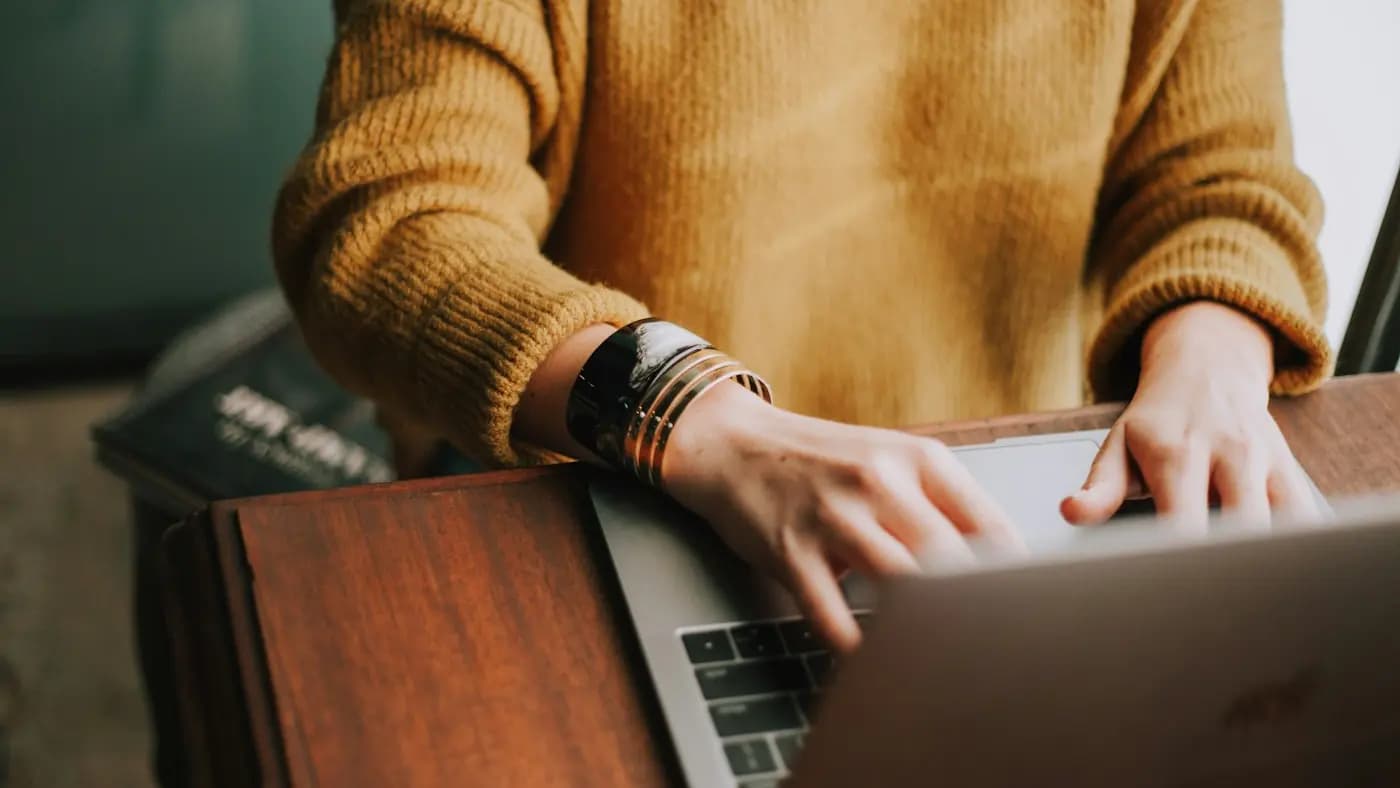 Person using a laptop with a coffee cup nearby