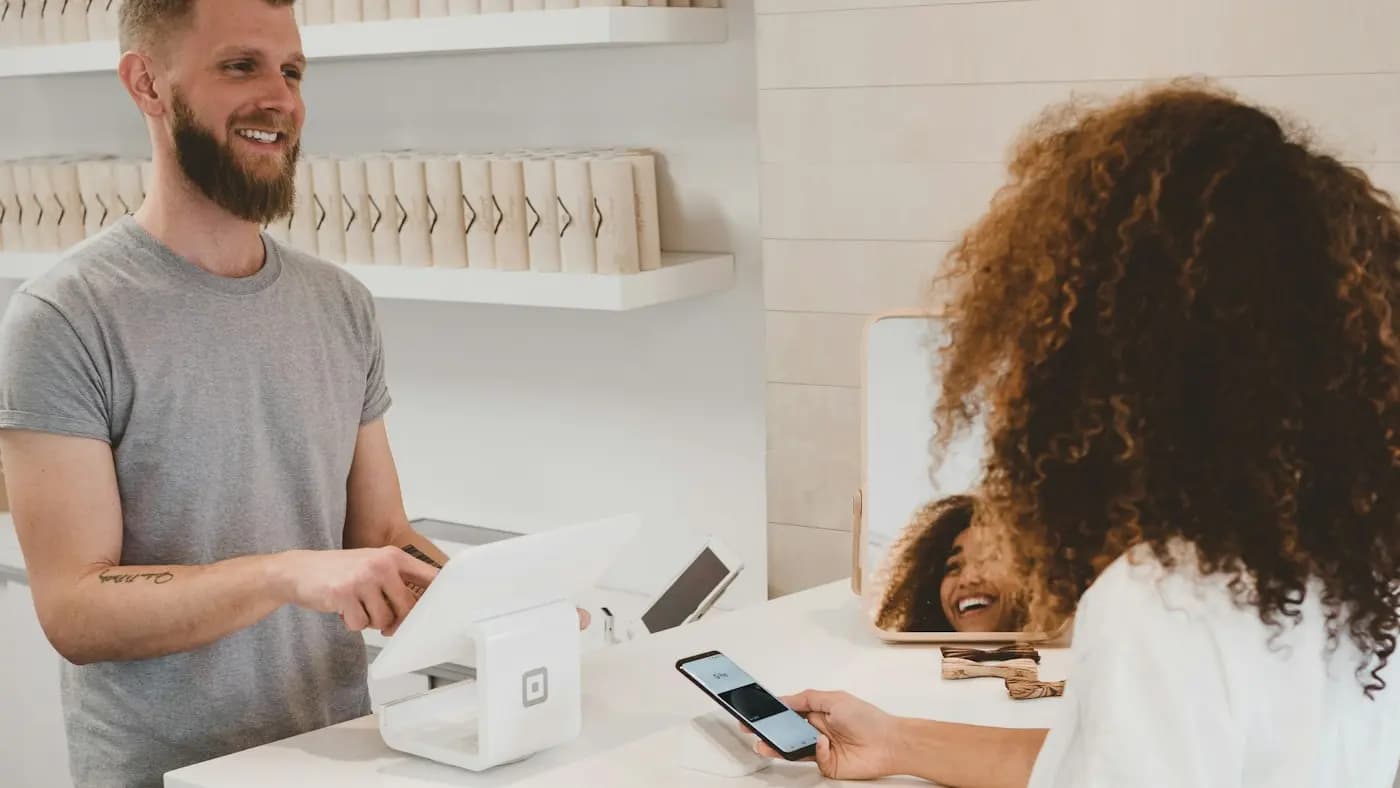 Shop assistant and customer making a mobile payment at a counter