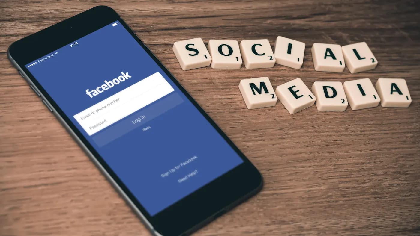Phone showing a social network login beside wooden letter tiles